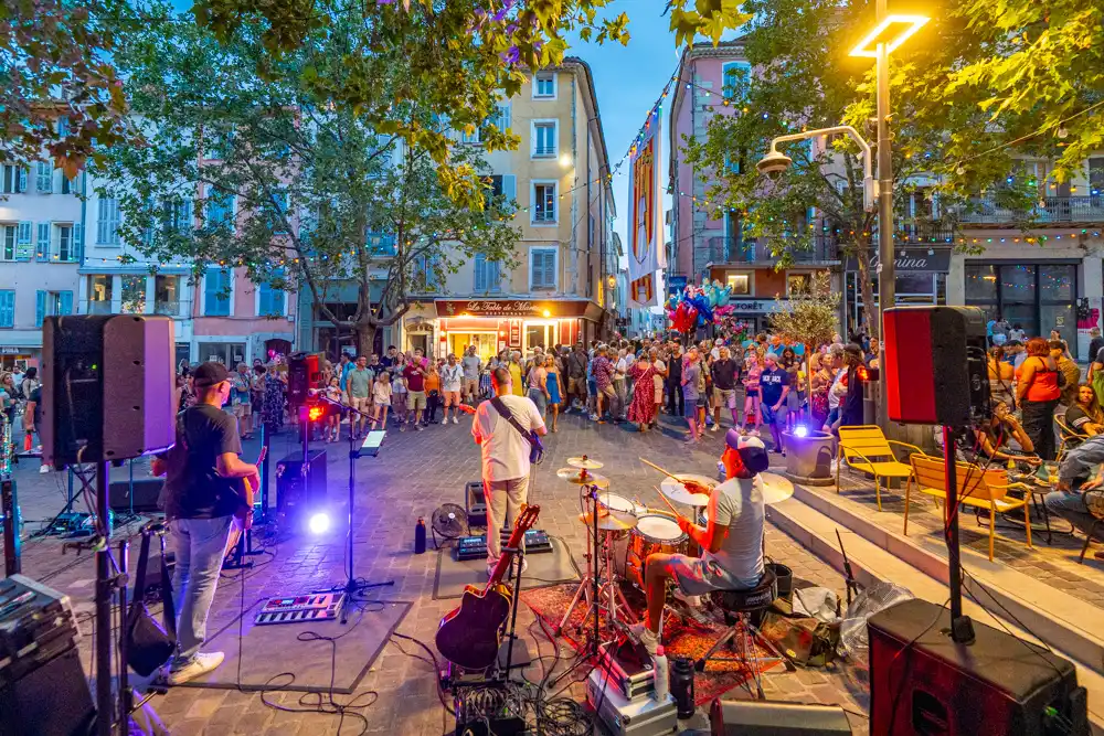 Groupe de musique jouant sur une place de Draguignan lors de la Fête de la musique, devant un public nombreux.