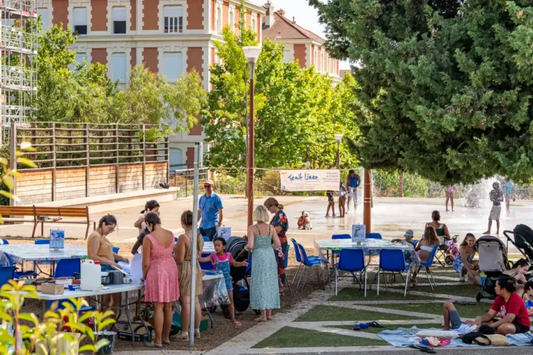 Atelier d'arts plastiques en plein air de l'association Trait Libre au parc Chabran, avec des participants de tous âges autour de tables d'activités.