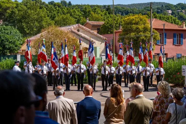 Cérémonie commémorative de la Libération de Draguignan avec des porte-drapeaux en uniforme alignés devant un public.