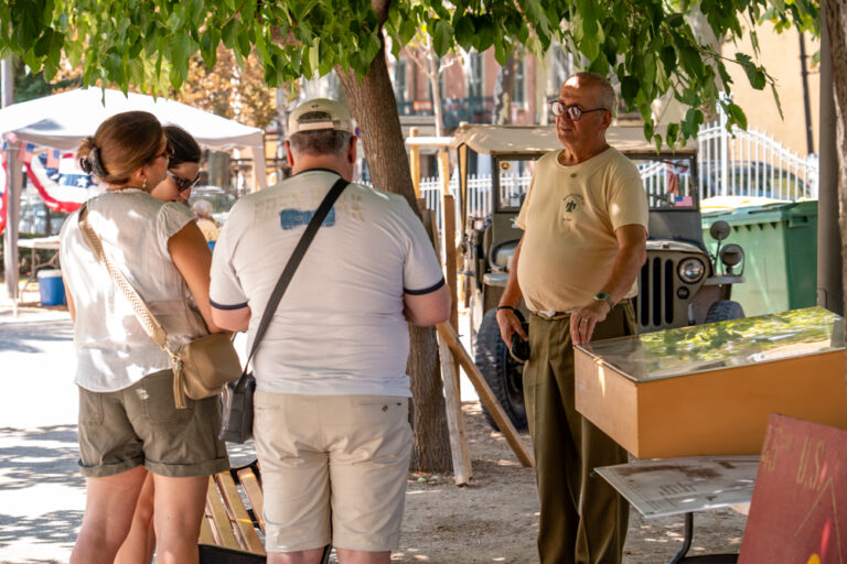 Un membre de l'association Delta Force 44 présente des objets historiques à des visiteurs dans le camp militaire reconstitué au jardin Anglès.