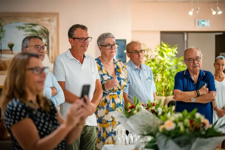 Un groupe de personnes assiste à la remise de la Légion d’honneur à Albert Donnat au sein de l’établissement Tonus Vitamine.
