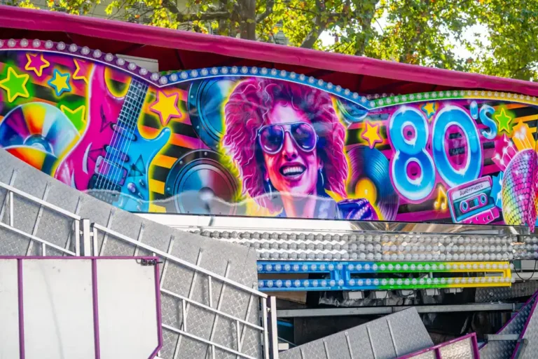 Décoration colorée d'un manège sur le thème des années 80, avec une guitare électrique, une personne portant des lunettes de soleil et une cassette audio.