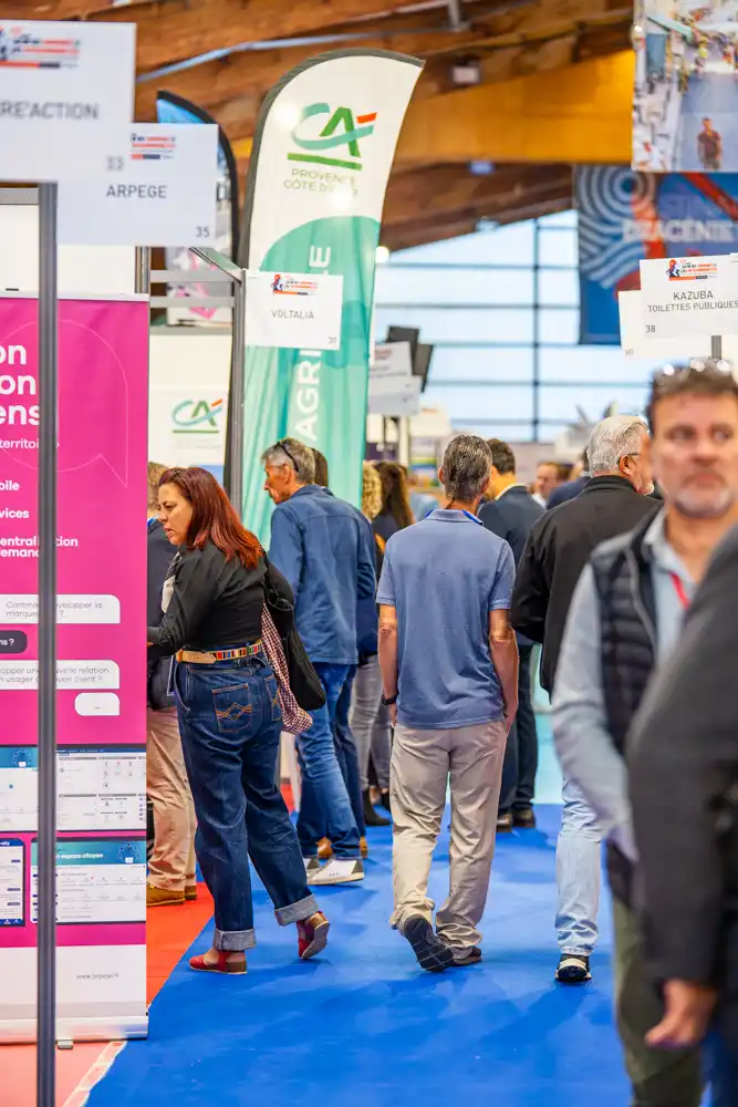 Visiteurs circulant dans les allées du salon des communes et intercommunalités du Var aux tennis couverts des Collettes.