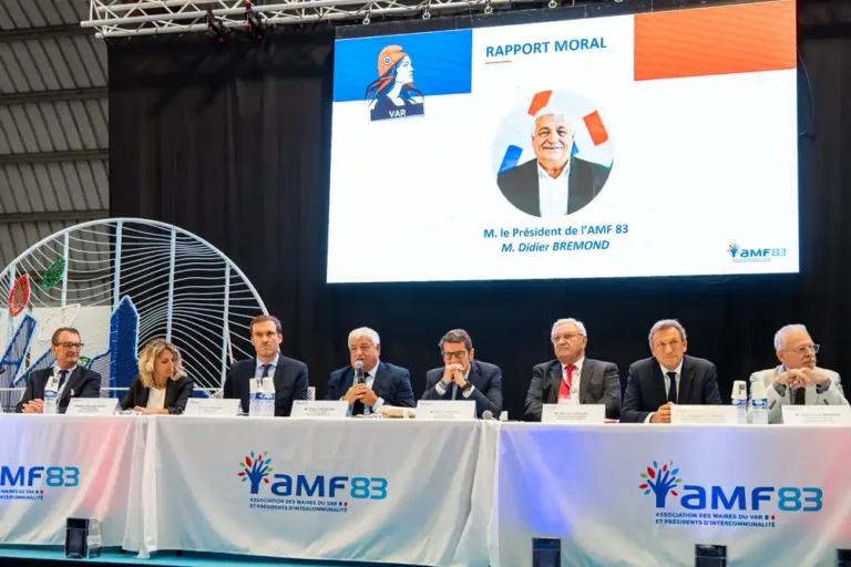 Tribune officielle lors de l'inauguration du salon des communes et intercommunalités du Var, avec Didier Bremond, président de l'AMF 83, s'exprimant au micro devant les élus.